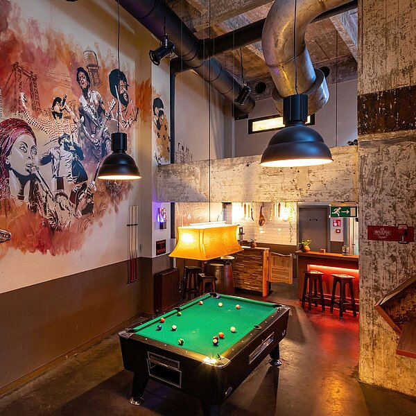 Recreational area at MEININGER Hotel Bruxelles City Center with pool table, musician wall art, and chic design.