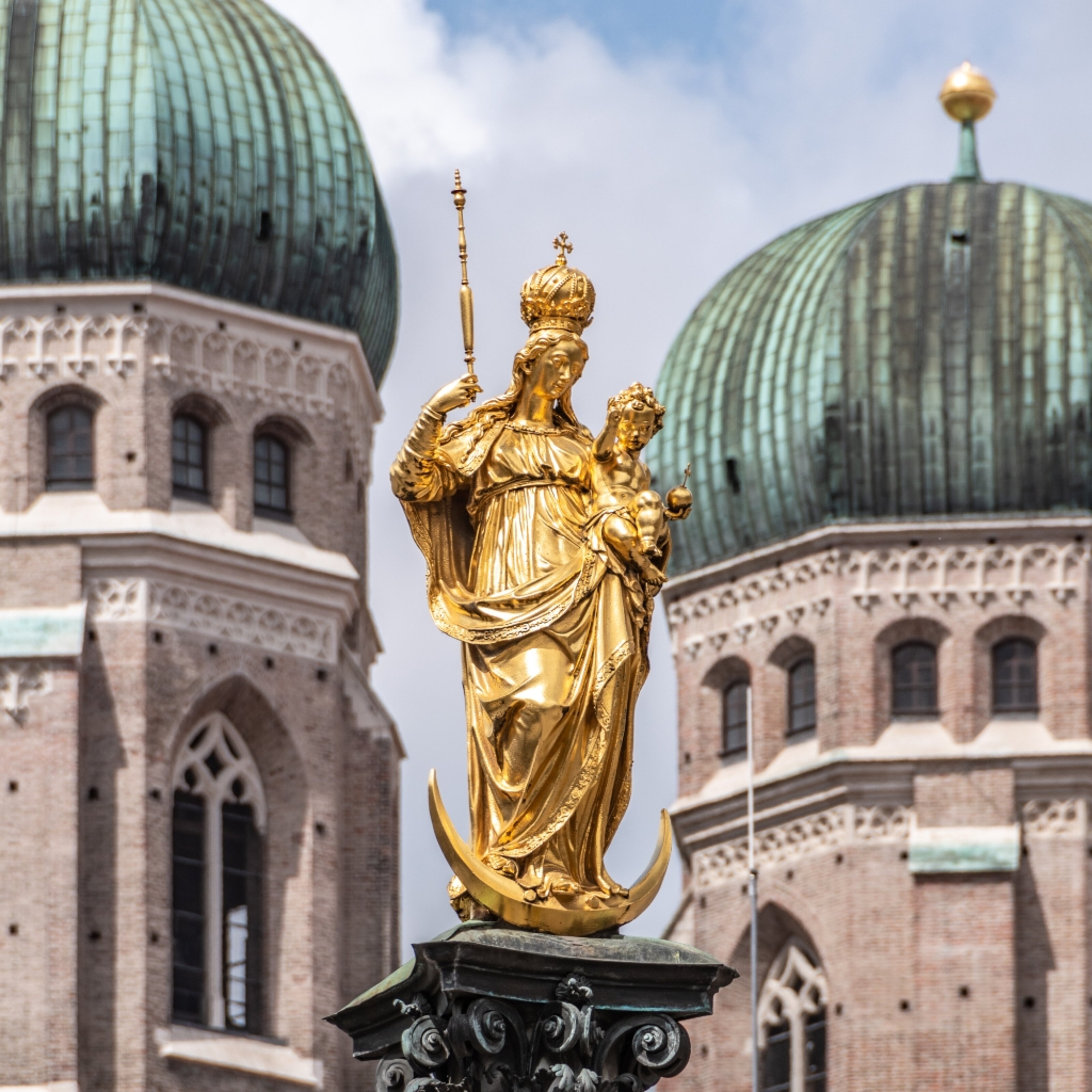 Close-up of the Mariensäule statue and Frauenkirche domes in Munich, near MEININGER Hotels.