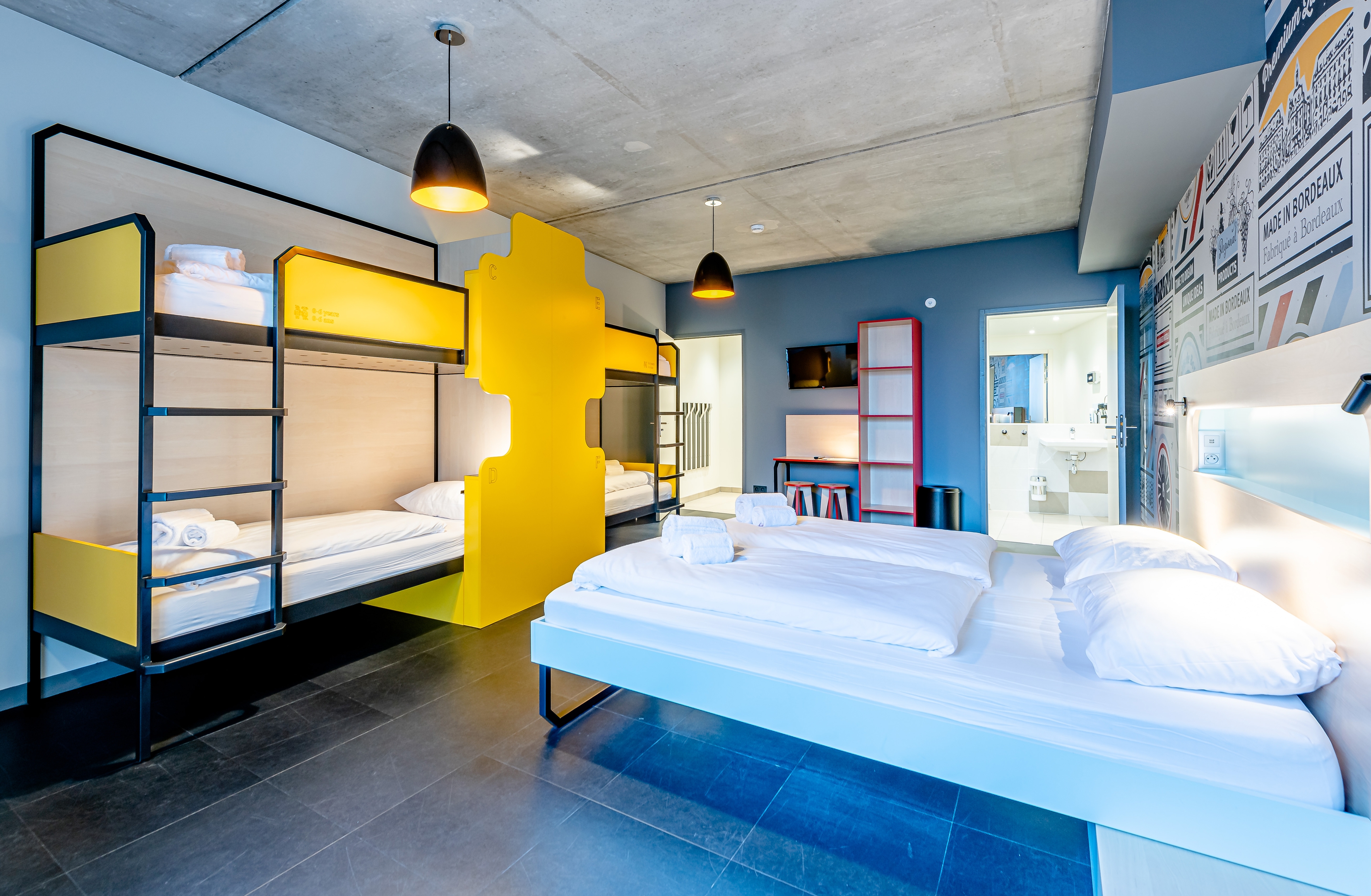 A multi-bedded room with a double bed and bunk beds suitable for a group stay at MEININGER Hotels